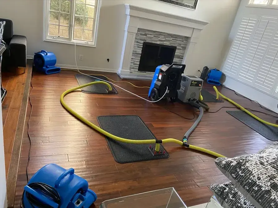 Restoration technicians drying a water damaged Forest Park, GA home with air movers and an extraction hose
