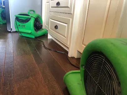 An air mover drying an appliance supply line leak in a Forest Park, GA kitchen