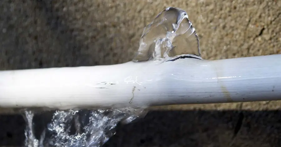 A burst supply pipe spraying water in a Forest Park, GA home